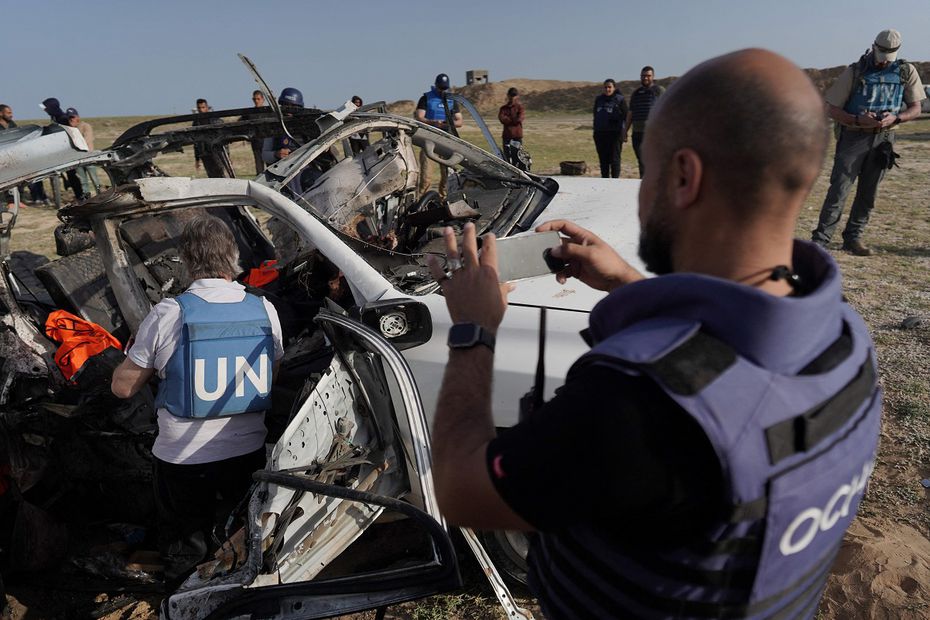Miembros del personal de las Naciones Unidas inspeccionan la carcasa de un vehículo utilizado por el grupo de ayuda estadounidense World Central Kitchen, que fue alcanzado por un ataque israelí el día anterior en Deir al-Balah, en el centro de la Franja de Gaza, el 2 de abril de 2024. FOTO: AFP