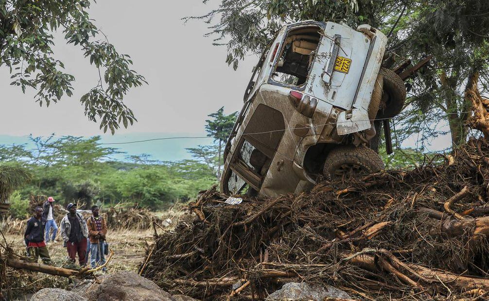 La gente mira un automóvil dañado después de inundaciones repentinas en Mai Mahiu, en la región del Valle del Rift de Naivasha, Kenia. Foto: EFE
