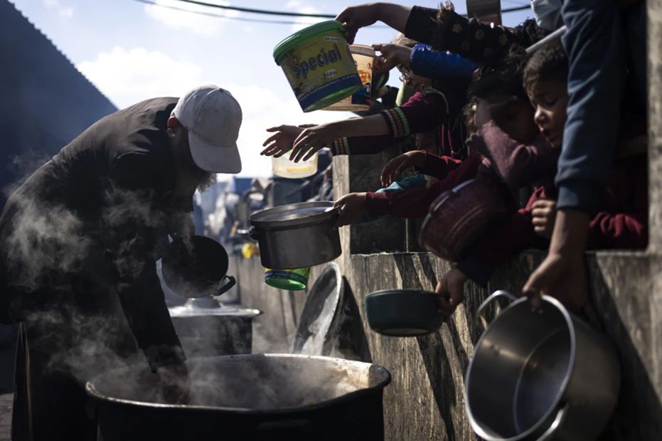 Palestinos hacen fila para recibir una comida gratis en Rafah, Franja de Gaza. Foto: AP