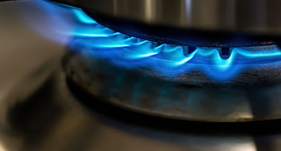 Un quemador de gas encendido arde con una llama azul en una estufa