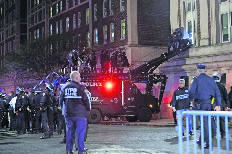 Oficiales de la policía de Nueva York con equipo antidisturbios irrumpen en un edificio de la Universidad de Columbia. Foto:  KENA BETANCUR / AFP