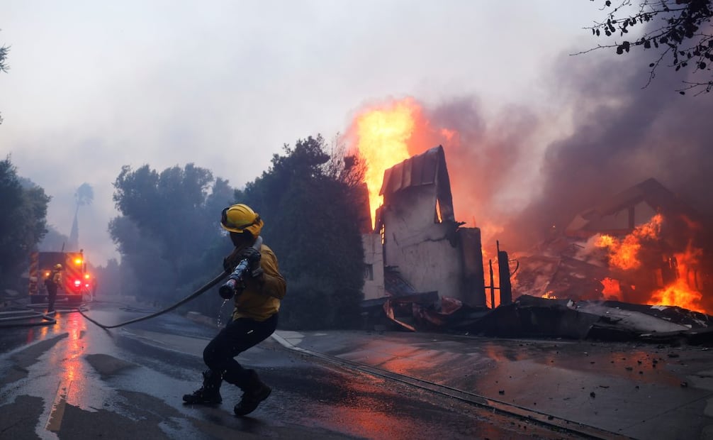 Un bombero intenta contener el avance de un incendio que consume una estructura en Pacific Palisades, el martes 7 de enero de 2025, en Los Ángeles. Foto: AP