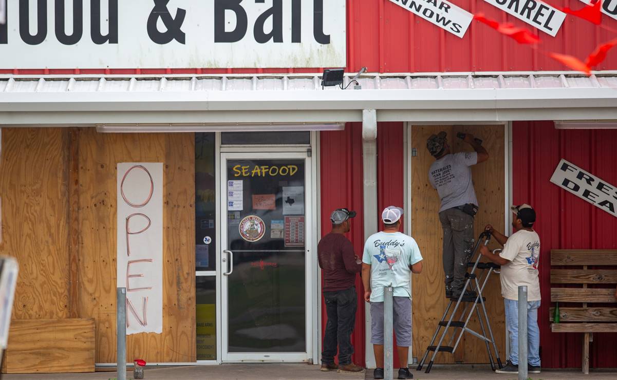 Los trabajadores se embarcan en la puerta de un negocio antes de que la tormenta tropical Beryl. Foto: EFE