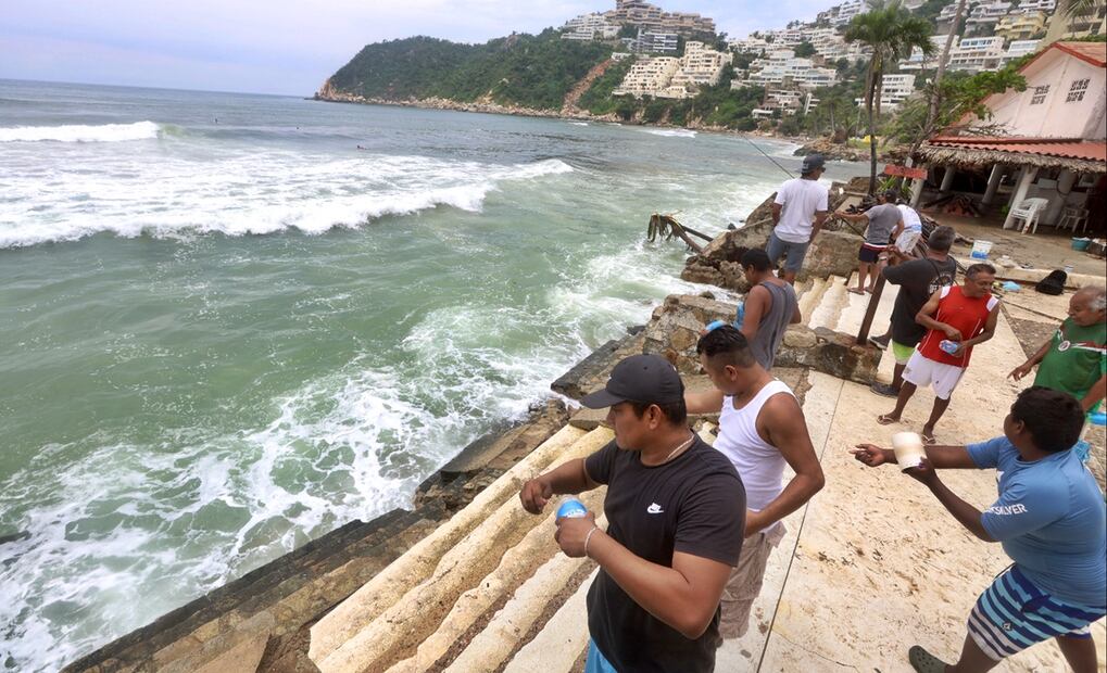 Desde una de las barras de la playa, con el mar grisáceo y agitado, y cerca de los almendros que reverdecieron después del huracán Otis, varios hombres lanzan cañas y redes para pescar algo que llevar a sus mesas. Foto: Valente Rosas/EL UNIVERSAL