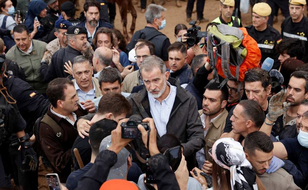 El rey Felipe habla con vecinos de Leitur durante su visita este domingo. Gritos de 'fuera', así como lanzamiento de barro, están recibiendo a la comitiva de los reyes de España, el presidente del Gobierno, Pedro Sánchez, y el president de la Generalitat, Carlos Mazón, a su llegada al centro de Paiporta. Numerosas personas indignadas han recibido con insultos a la comitiva y se han encarado con ella, mientras que tanto el rey como la reina ha intentado mediar con jóvenes que se les han acercado. Foto: EFE