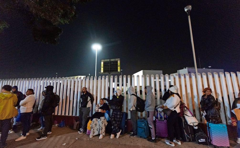 Migrantes de Cuba y Venezuela hacen fila en el puesto de control de inmigración mexicano, en Tijuana, mientras cruzan la frontera para solicitar asilo en Estados Unidos. Foto: Gregory Bull / AP