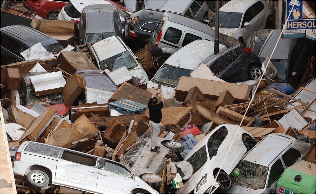 Vehículos amontonados en una calle tras las intensas lluvias en Valencia, España. Foto: EFE