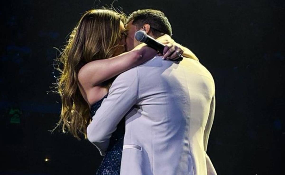 Cynthia Rodríguez y Carlos Rivera se besan en el escenario. El cantante celebró 20 años de carrera. Foto: Instagram Carlos Rivera.
