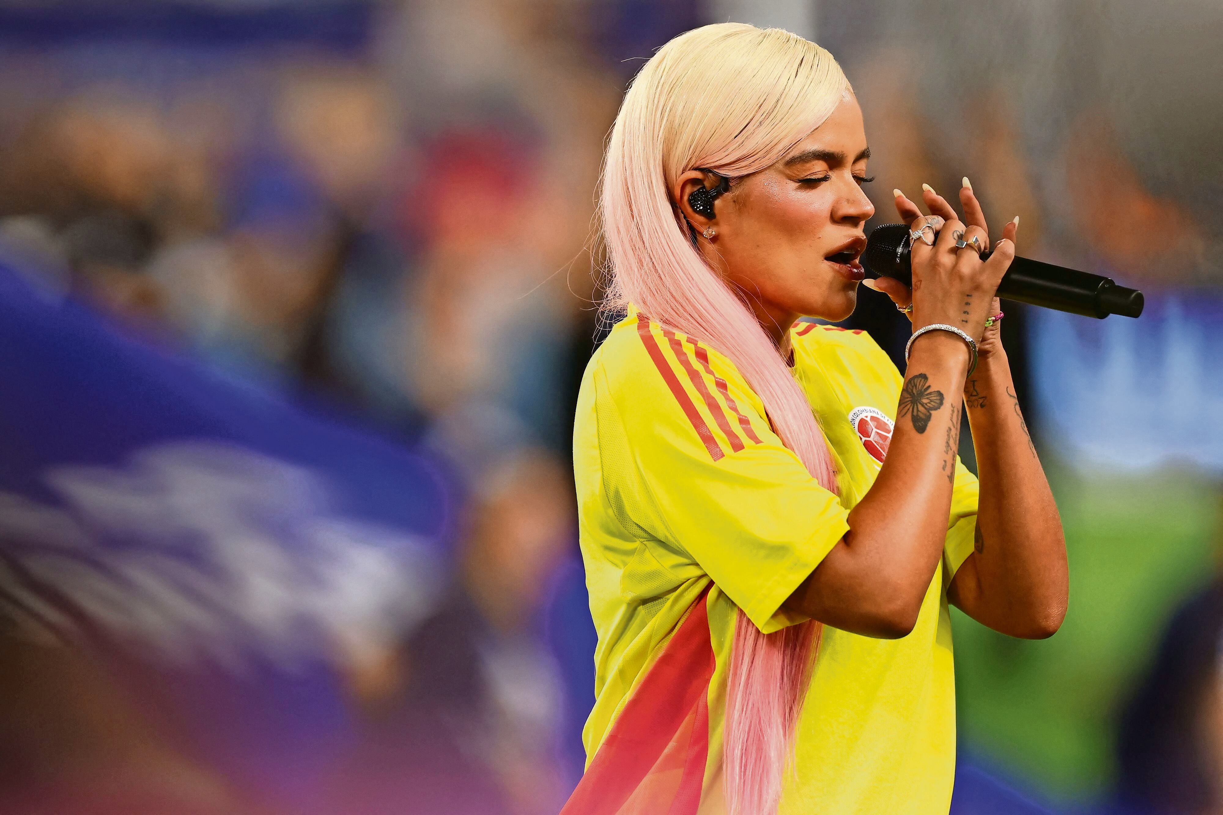 Karol G, portando una playera de la selección colombiana, entonó el himno de su país. Foto: AFP