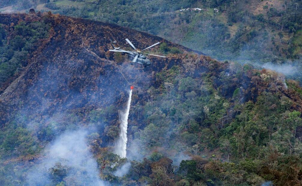 Fotografía cedida por la presidencia de Perú del desplazamiento de helicópteros con el sistema Bambi bucket en la zona de la Florida en Amazonas. Foto: EFE