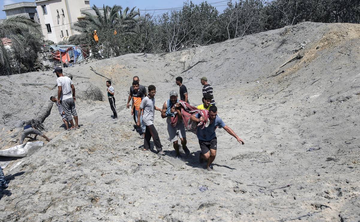 Palestinos llevan un cuerpo en el lugar de los hechos tras un ataque aéreo israelí en la zona de Al-Mawasi de Khan Yunis. Foto: EFE
