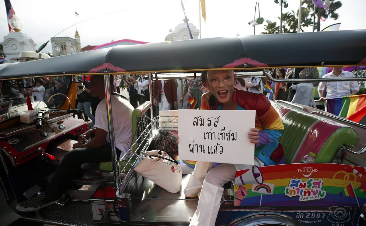Un miembro de la comunidad LGBT+ sostiene un cartel que dice en tailandés "Se aprueba la Ley de Igualdad en el Matrimonio". Foto: EFE