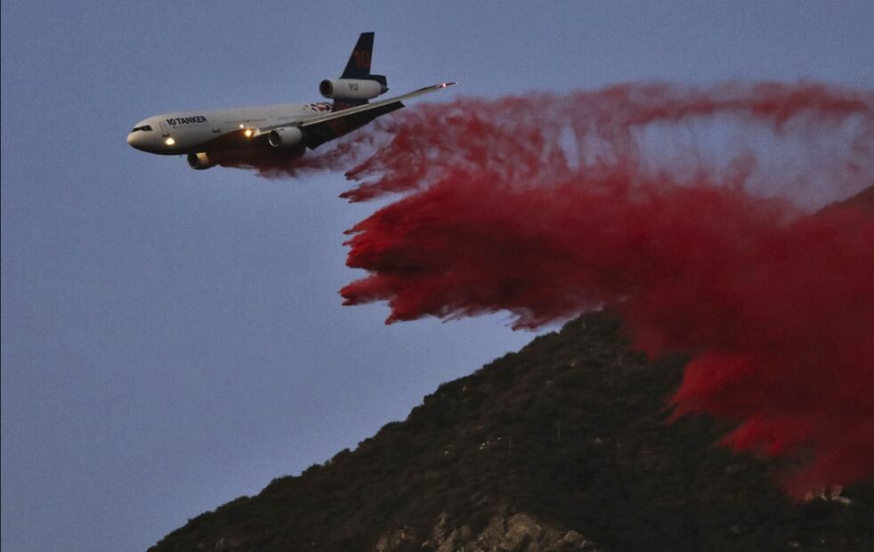 Un avión de extinción de incendios arroja el retardante de fuego Phos-Chek mientras el incendio continúa en Pacific Palisades, California, el 7 de enero de 2025. Foto: AFP