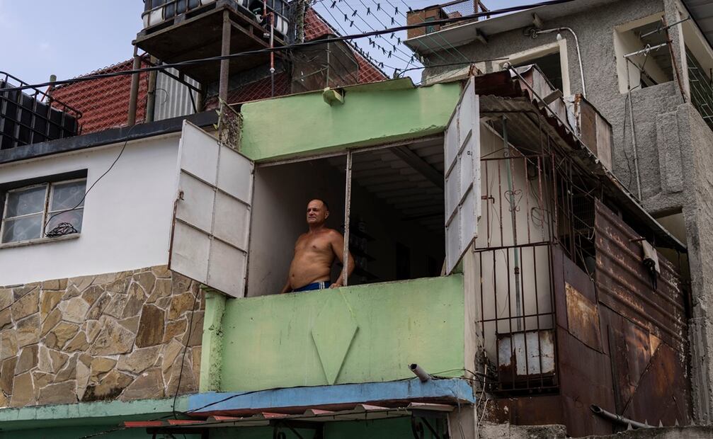 Un hombre mira por la ventana durante un apagón matutino programado en Regla, Cuba. Foto: AP 