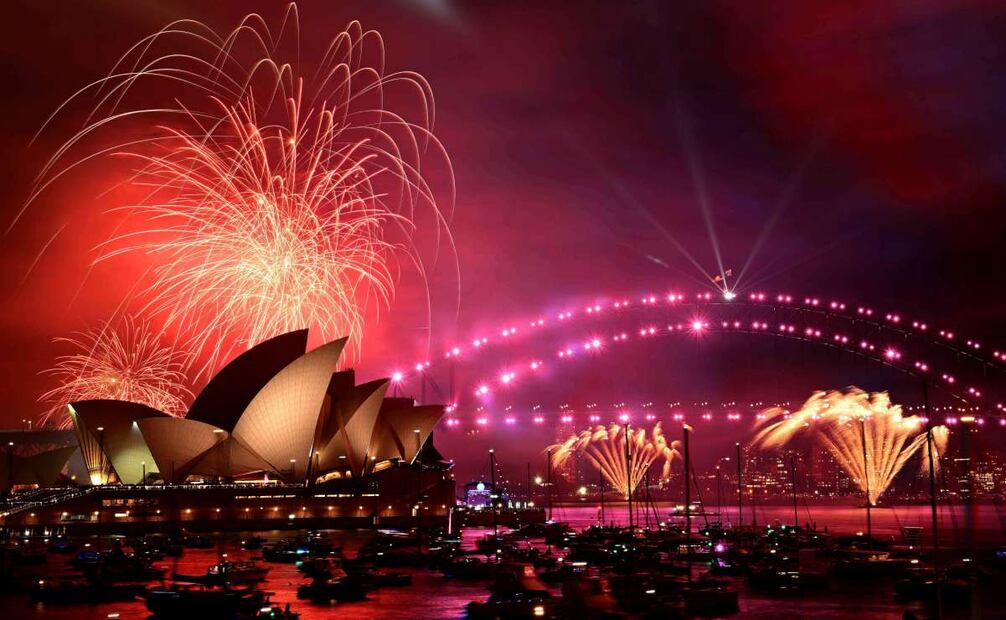 Fuegos artificiales iluminan el cielo sobre la Ópera y el Puente del Puerto durante las celebraciones del Año nuevo en Sydney, Australia. Foto: EFE