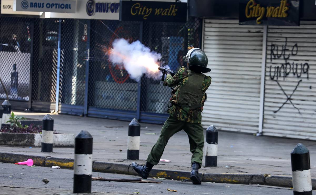 Un oficial de policía dispara gases lacrimógenos contra manifestantes durante una protesta contra los aumentos de impuestos propuestos. Foto: EFE