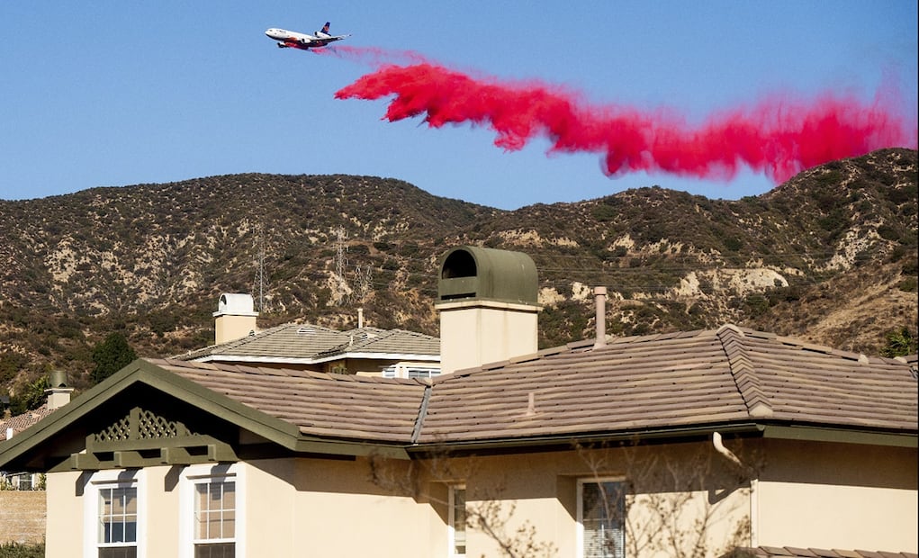 Un avión de extinción de incendios arroja el retardante de fuego Phos-Chek mientras el incendio continúa en Pacific Palisades, California, el 7 de enero de 2025. Foto: AFP