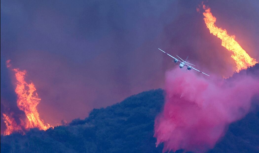 Un avión de extinción de incendios arroja el retardante de fuego Phos-Chek mientras el incendio continúa en Pacific Palisades, California, el 7 de enero de 2025. Foto: AFP