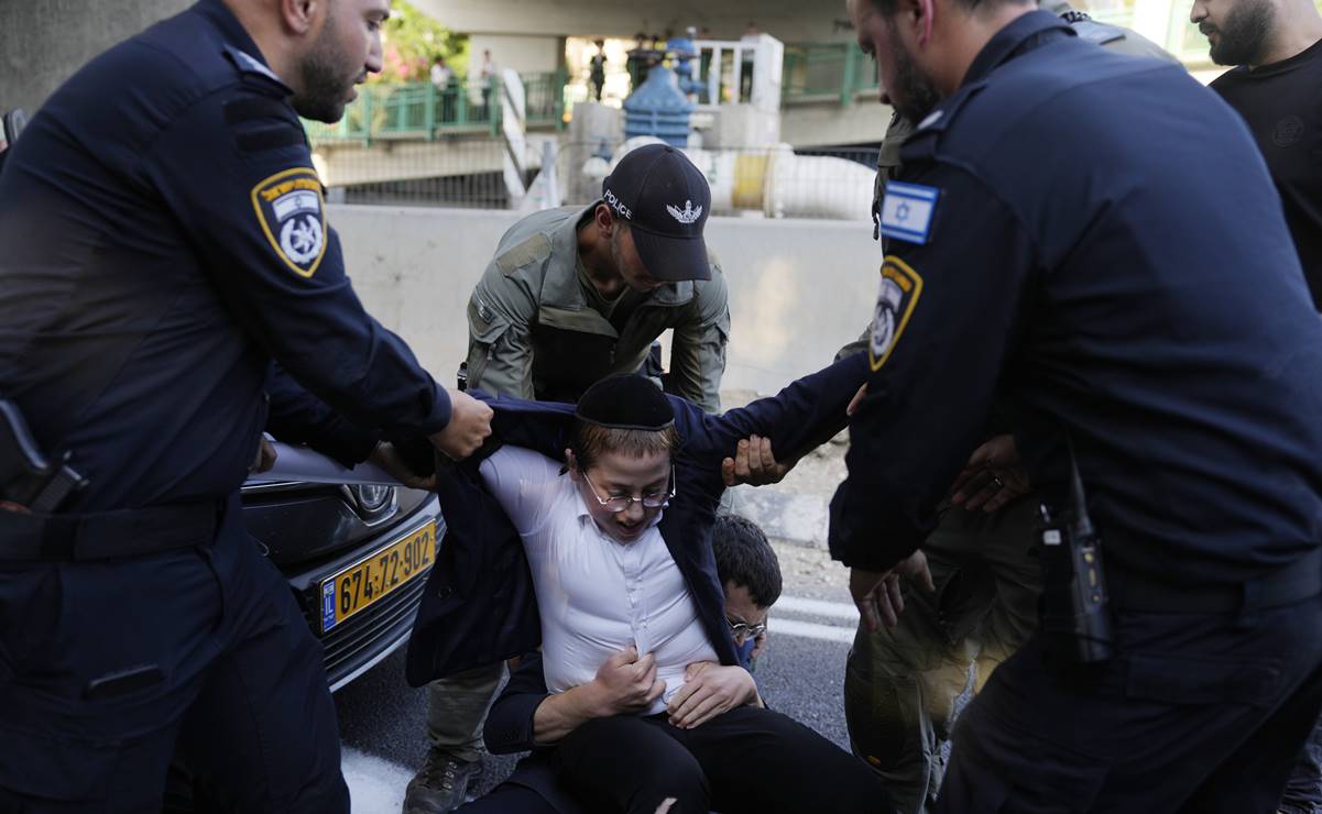 La policía israelí retira a jóvenes judíos ultraortodoxos que bloquean una carretera para protestar contra el reclutamiento militar en Bnei Brak. Foto: AP