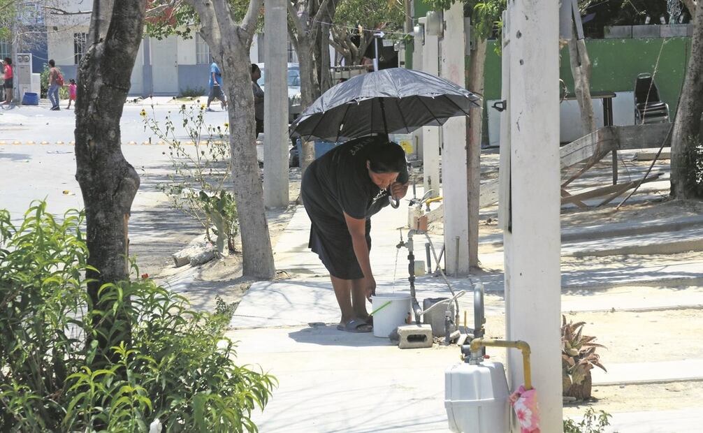 Habitantes aprovechan la poca agua que sale de llaves de la calle para llenar algunos recipientes pequeños, pues el líquido cae muy lento. Foto: Emilio Vásquez/ EL UNIVERSAL.